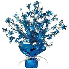 a blue vase filled with lots of flowers on top of a white table next to a ribbon