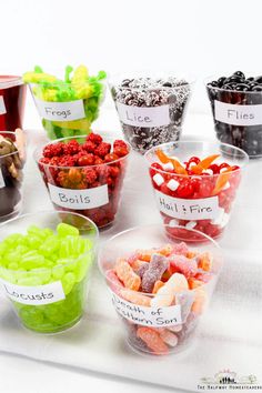 there are many different types of candies in the bowls on the table with name tags