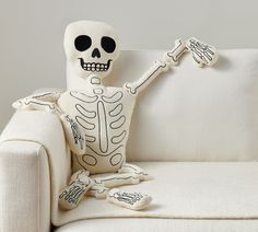 a skeleton sitting on top of a white couch