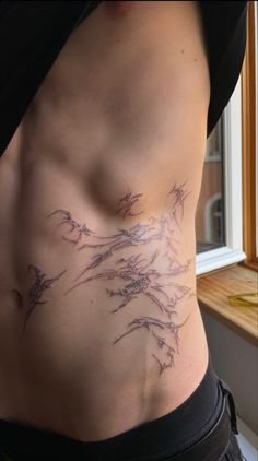 a woman's stomach with an artistic tattoo design on her belly and lower back