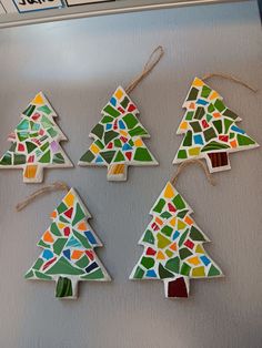 four stained glass christmas trees hanging on a refrigerator