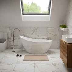 a white bath tub sitting under a window in a bathroom