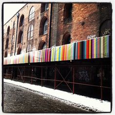 an old building with lots of windows and graffiti on the side