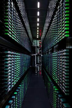 rows of wine bottles are lined up in a dark room with lights on the ceiling