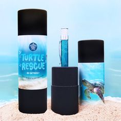 three different types of toiletries on the sand at the beach, one with a turtle