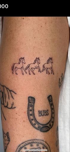 a tattoo with horses and horseshoes on it