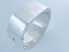 "Retro Wide Three Dimensional High Polish Shine Sterling Silver Geometric Hinged Bangle. Modernist inspiration with clean smooth 3 dimensional geometric lines create this bold aesthetically pleasing bangle. Good weight at 47.18 grams. Lightly polished  buffed ready to wear.  Stamped Maker: 925 Stamped Size: 6 3/4\" inside circumference, 2 1/4\" inside diameter across and 1.0\" wide.   Weight: 47.318 grams Condition: Pre owned item that has been polished buffed and is ready to wear. Reflecting so Modern Polished Sterling Silver Bracelet, Formal Modern Sterling Silver Bracelet, Modern Bangle With Sterling Silver Clasp, Contemporary Sterling Silver Bracelet For Formal Occasions, Modern Sterling Silver Bangle Bracelet For Formal, Modern Sterling Silver Bangle Bracelet For Formal Occasions, Modern Sterling Silver Bangle For Formal Occasions, Modernist Polished Sterling Silver Bangle, Modern Sterling Silver Bracelet, Rectangular Shape