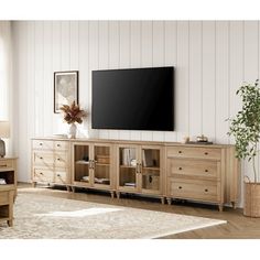 a living room with a large flat screen tv on top of a wooden entertainment center