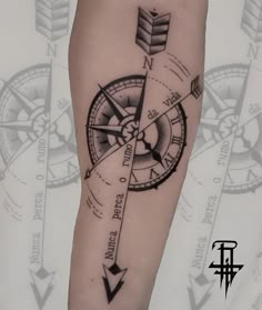 a black and white photo of a compass tattoo on the left arm with arrows pointing in different directions