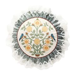 a white doily with flowers and two birds on it's center, surrounded by lace