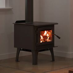 a wood burning stove in the corner of a room with no one around it,