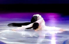 two people are performing on the ice in an artistic dance pose with their arms around each other