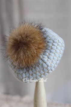 a knitted hat with a fur ball on top