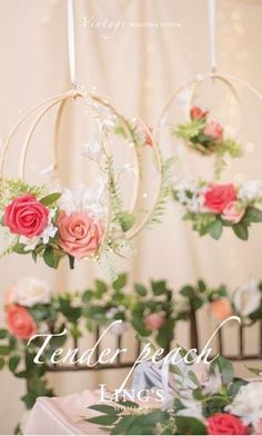 the wedding flowers are hanging from the hoop on the wall above the table and in front of the ceremony backdrop