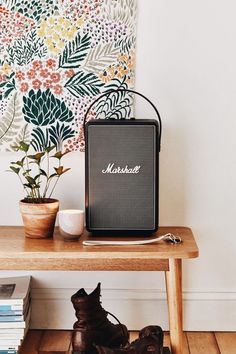 a wooden table topped with a radio next to a plant