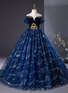 Every inch of this dress exudes elegance and fairy-tale allure! From the moment you slip into this stunning midnight blue gown, you'll feel like a princess stepping into a starry night. The golden embroidered detailing on the bodice creates a striking contrast against the deep, velvety fabric, making it both regal and radiant. The off-shoulder sleeves give a soft and ethereal feel, while the full tulle skirt, dotted with twinkling stars, ensures every movement is graceful and captivating. Perfect for a prom or any grand occasion, this dress brings a dreamy celestial charm to life, allowing you to shine under the spotlight with confidence and grace. Royal Blue Princess Dress For Wedding, Gold Princess Gown For Prom Season, Gold Princess Gown For Prom, Gold Princess Gown For Debutante Ball, Princess Style Gold Gown For Prom, Princess Style Gold Gown For Debutante Ball, Silver Homecoming Dresses, Vintage Simple Wedding Dress, Robes Quinceanera