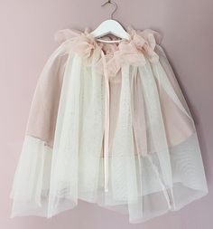 Tulle Cape  Cream tulle cape with pink ruffle. Fully lined in rose lining and pink satin tie.  These capes are suitable for age 4-8 years and have a tie fastening at the front. Pink Ruffled Tulle Fabric For Spring, Spring Pink Ruffled Tulle Fabric, Cape With Hood, Costume Capes, Tulle Cape, Cape Tops, Dress Up Boxes, Pink Ruffle, Clothing Design