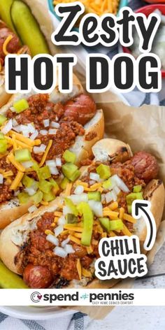 two chili dogs in buns with cheese and pickles