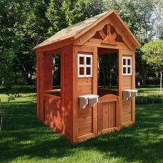 a small wooden structure in the middle of some grass