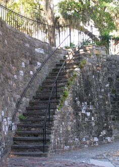 an old stone wall with stairs leading up to it