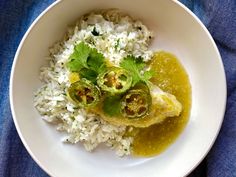 a white plate topped with rice and green garnish next to some cilantro