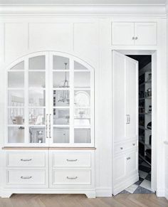 a white cabinet with glass doors and drawers