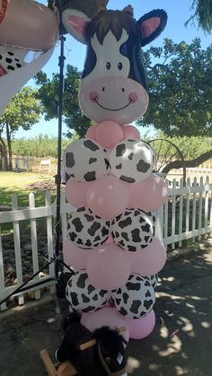 a bunch of balloons are stacked on top of each other in the shape of a cow