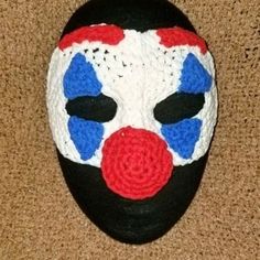 a crocheted clown mask is laying on the floor