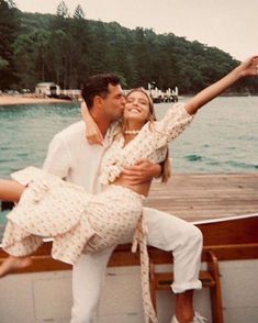 a man and woman on a boat in the water with their arms around each other