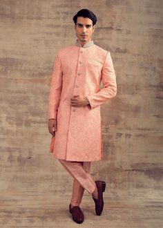 Featuring this Peach Budcolour Sherwani in Resham embroidery. This Sherwani set is fully embroidered with ivory colour Resham and collars and buttons are hand-embroidered in silver colour. It can be paired with churidaar as well. Perfect fit for any wedding function. Brand: Panache Haute Couture Availability: Online and In-store Delivery Time: 4-6 Weeks Fabric: Sherwani - Silk and Bottom (Churidaar) - Lycra Satin or Trouser - Raw Silk Customisation: For more colour options please contact our tea Ceremonial Pink Sherwani With Chikankari Embroidery, Ceremonial Pink Bandhgala With Resham Embroidery, Elegant Pink Sherwani For Ceremonial Occasions, Resham Embroidery, Ivory Colour, Wedding Function, Silver Colour, Thread Work, Ivory Color