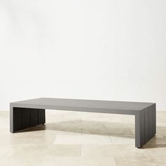 a large gray table sitting on top of a white tiled floor next to a wall