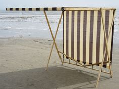 an empty beach chair sitting on the sand