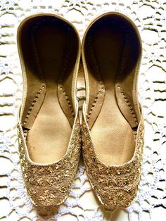 Hand crafted & Hand embroidered  Leather shoes in a beautiful bronze color embellished with rich gold thread work - often called Zardozi Zardozi comes from two Persian words: zar, meaning 'gold', and dozi, meaning 'work'. Zardozi embroidery is a type of metal embroidery. Zardozi embroidery work involves making elaborate designs using gold threads .  Khussa is a style of South Asian handcrafted footwear produced in Punjab Pakistan.Khussa are made by artisans by hand. The uppers are made of one pi Gold Slip-on Heels For Wedding, Festive Embellished Closed-toe Flats, Festive Embellished Closed Toe Flats, Zari Work Flats For Diwali Reception, Flats With Zari Work For Diwali Reception, Festive Zari Work Flats For Reception, Bollywood Style Flats For Diwali Party, Bollywood Style Festive Flats For Reception, Diwali Reception Flats With Zari Work