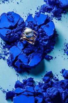 a ring sits on top of some blue powdered rocks and looks like it is melting