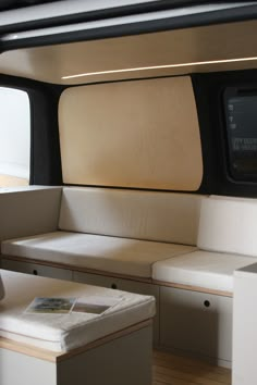 the inside of a boat with white cushions