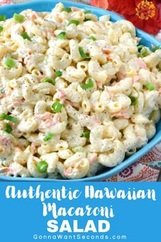 a blue bowl filled with macaroni salad on top of a colorful table cloth