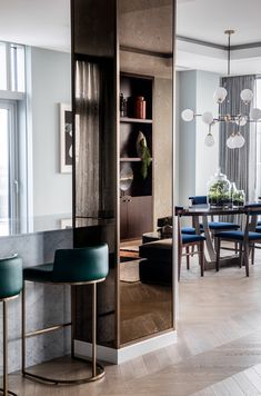 a dining room table and chairs in front of a glass door that leads to the kitchen