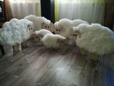 four sheep are standing in the middle of a wood floor with fake wool on them