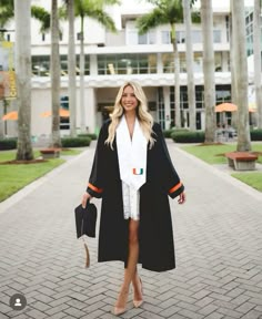 a woman is walking down the street wearing a graduation robe