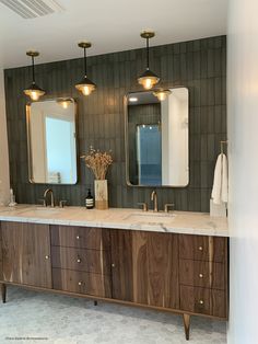 a bathroom with two sinks, mirrors and lights on the wall next to each other