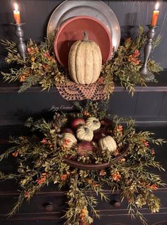 a table with candles, plates and pumpkins on it