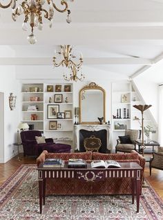 a living room filled with furniture and a fire place in the middle of a room