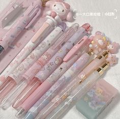 many pens are lined up in a row on top of each other, with hello kitty characters