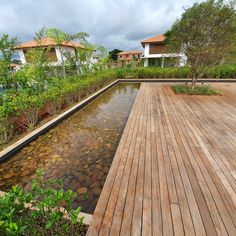 a wooden deck next to a small pond