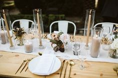 the table is set with candles, flowers and other items for an elegant wedding reception