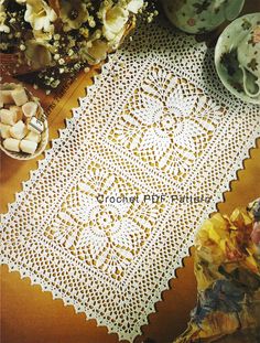 an old doily is laying on a table next to some flowers and other items