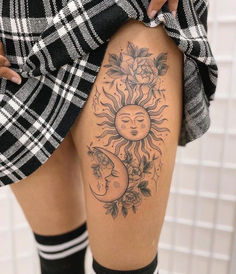 a woman with sun and moon tattoo on her thigh