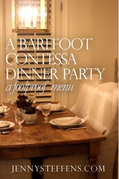 a wooden table with plates and glasses on it in front of a window that says barefoot contessa dinner party