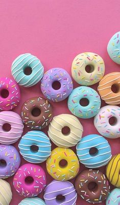 there are many different donuts with sprinkles on them and one is pink