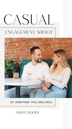 a man and woman sitting at a table in front of a brick wall with the title casual engagement shoot